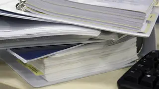Folders full of paper beside a laptop keyboard