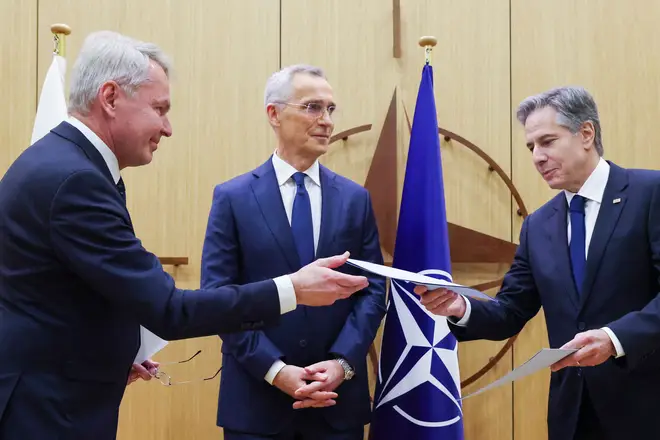 Finnish Foreign Affairs Minister Pekka Haavisto (L) hands over Finland's accession to NATO documents to US Secretary of State Antony Blinken