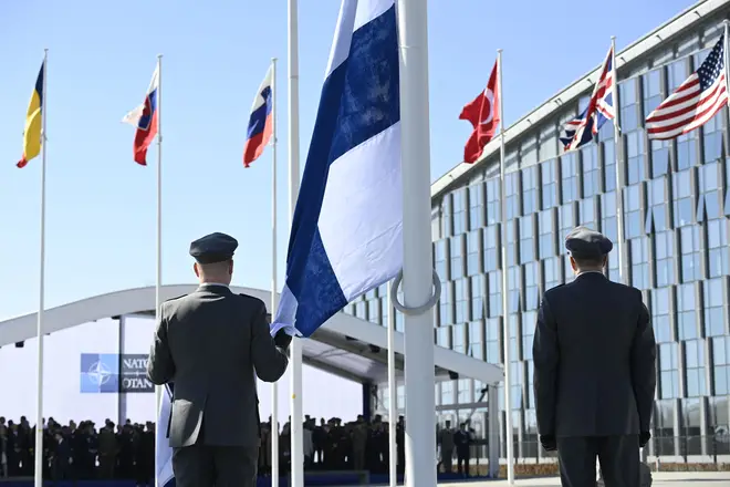 Finnish military personnel install the Finnish national flag at the NATO headquarters in Brussels,