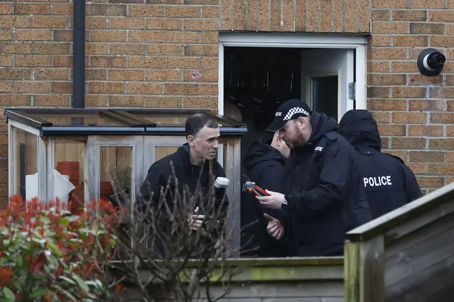Police examine a set of pruning shears in the couple's back garden