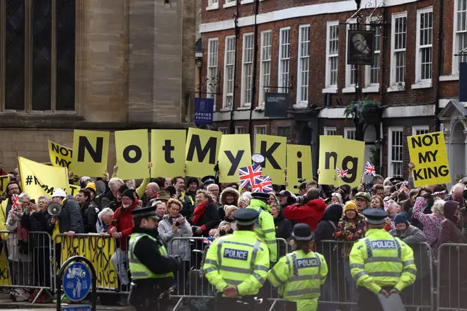 Protesters hold up placards saying 'Not My King' ahead of Charles' arrival