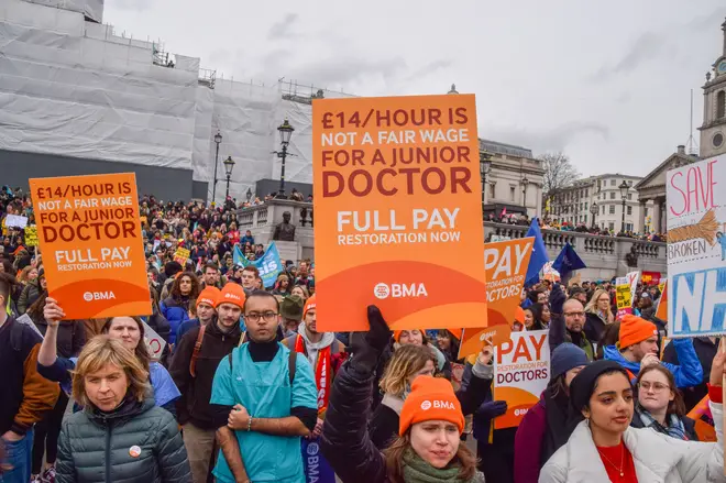 A junior doctor holds a placard calling for fair pay during their last strike in February