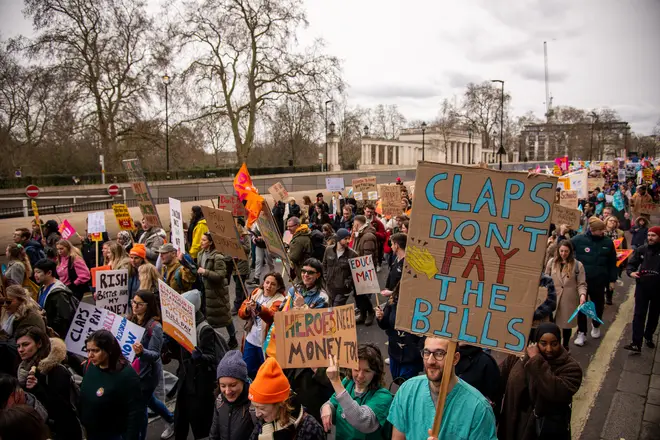 Protestors hold placards expressing their opinion during the Budget Day Protest held in Central London