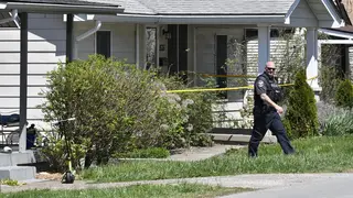 A Louisville Metro Police officer walks outside the home of the gunman in the Camp Taylor neighbourhood in Louisville