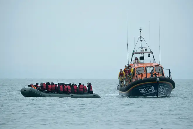 Migrants are helped by RNLI (Royal National Lifeboat Institution) lifeboat before being taken to a beach in Dungeness