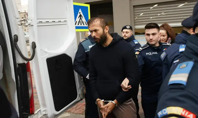 Andrew Tate in handcuffs getting into a police van