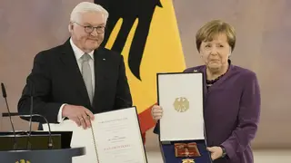 German President Frank-Walter Steinmeier, left, presents the Grand Cross of the Order of Merit of the Federal Republic of Germany in a special design to former chancellor Angela Merkel during a recept
