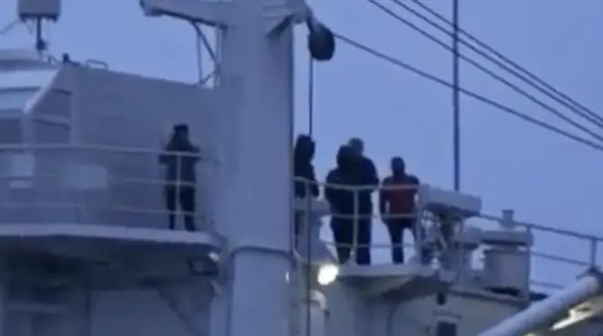 A group of men in all black could be seen congregating on the ship.