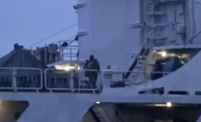 A man on the Russian vessel could be seen holding a weapon.