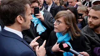 French President Emmanuel Macron argues with a person opposed to the pension reform in Selestat, eastern France
