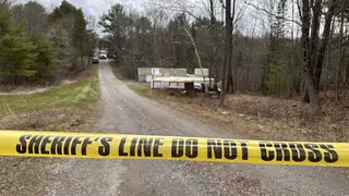 A sheriff’s department caution tape is set up at the entrance of a crime scene in Bowdoin, Maine