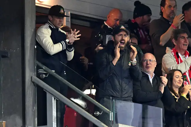 Rob McElhenney (L) and US actor and Wrexham owner Ryan Reynolds (C) watch on nervously during the game