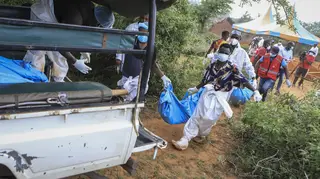 Police and local residents load exhumed bodies of into the back of a truck in the village of Shakahola, near the coastal city of Malindi, in southeastern Kenya