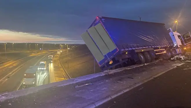The lorry was left hanging precariously off a bridge after the crash