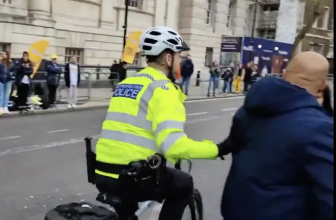 One cop on a bike appeared to push a member of the public out of the way ahead of the convoy