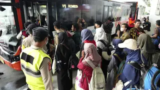 People walk to a bus at Soekarno-Hatta airport in Indonesia after being evacuated from Sudan