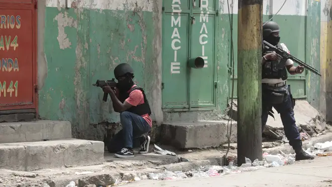Police officers take cover during an anti-gang operation in the Portail neighbourhood of Port-au-Prince, Haiti