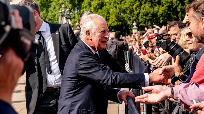 King Charles is pictured meeting members of the public outside Buckingham Palace the day after his mother's death last September