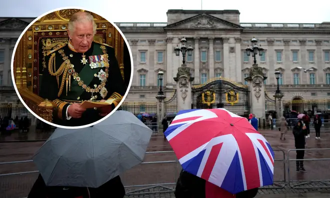 People sheltering themselves with union jack umbrellas outside Buckingham Palace
