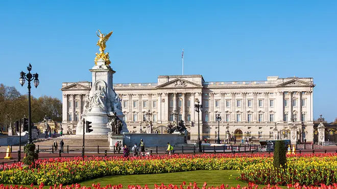 Buckingham Palace on a beautiful sunny day surrounded by red tulips
