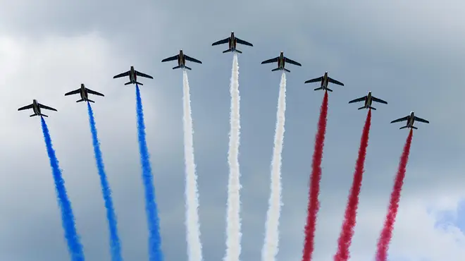 A royal flyover with aircrafts emitting red, white and blue smoke