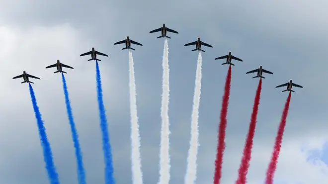 The Red Arrows performing above London with blue, white and red smoke emitting from them