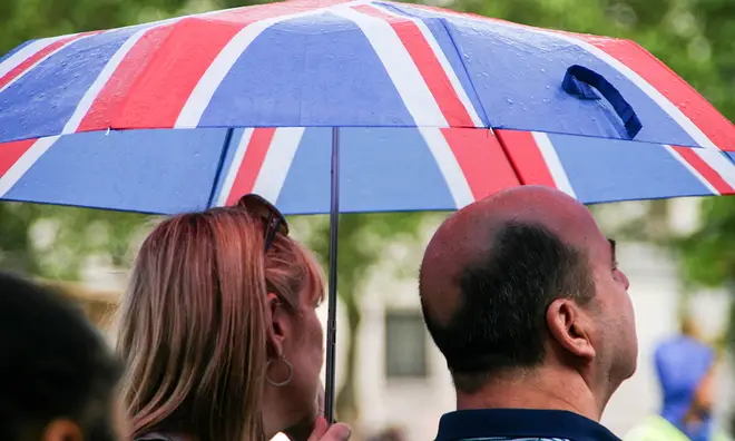 Couple under a Union Jack umbrella in a wet London