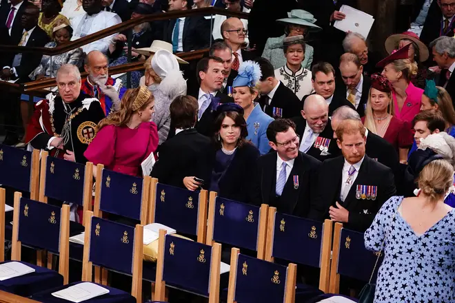As the King's Coronation got underway at Westminster Abbey, Prince Harry could be seen grinning from the third row beside senior royals.