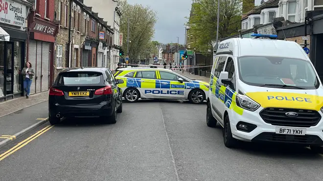 A pair of police vehicles are parked close to the scene of the 16-year-old's murder on Friday