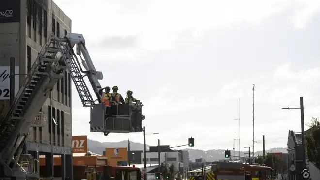 Investigators survey the scene after a fire at Loafers Lodge in Wellington, New Zealand