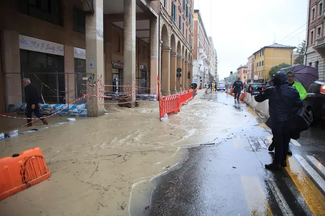 Sandbags are lined up along a flooded street in downtown Bologna