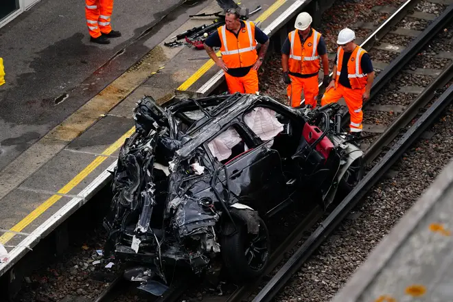 The mangled wreck ended up on train tracks after smashing into a Tesla dealership