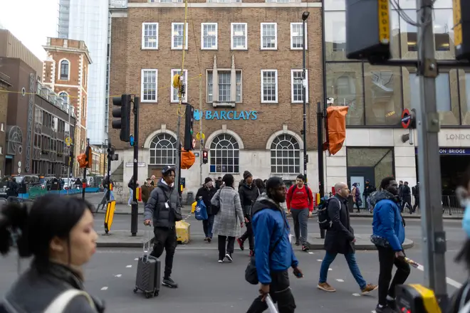 Pedestrians cross a main road in front of a Barclays Plc bank branch in the City of London, UK, on Thursday, Feb. 9, 2023.