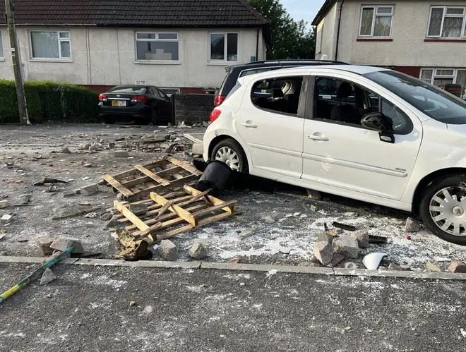 A vandalised car and debris strewn in the street after a night of rioting