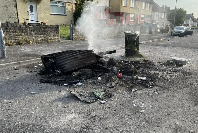 Smouldering debris in the street after riots broke out on a Cardiff estate