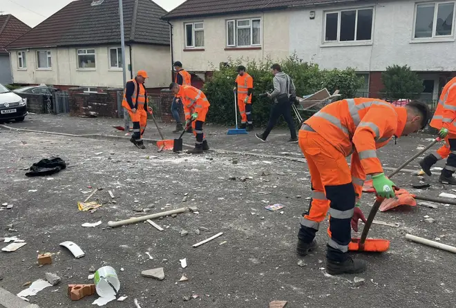 A team of workmen clears up debris after riots in Cardiff