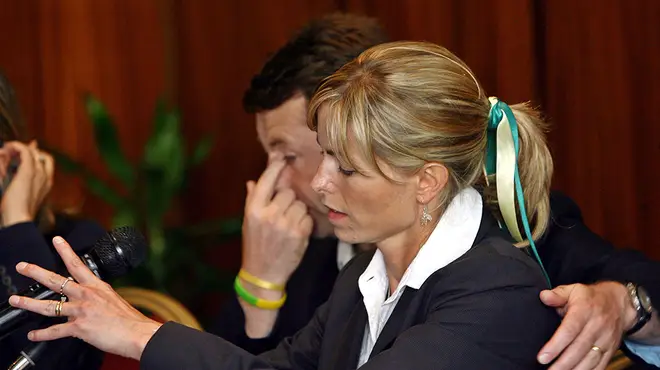Kate and Gerry McCann at a press conference wearing black and blue and yellow ribbons in her hair