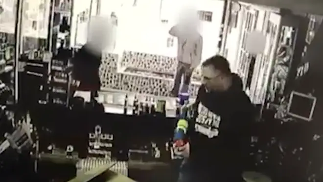 Shopkeeper uses water gun to defend shop.
