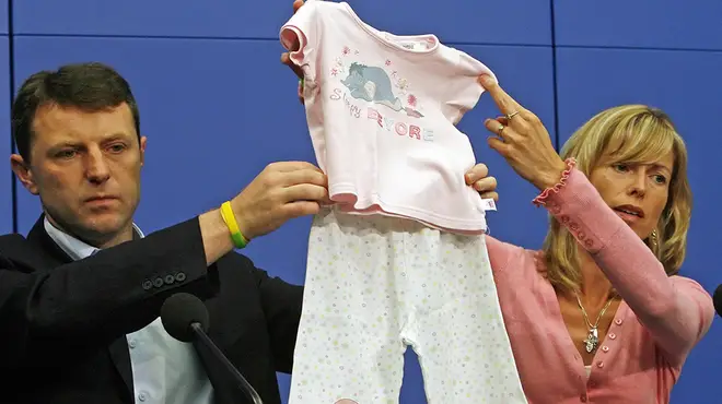 Madeline McCann's parents hold up the pjs she went missing in which are pink with Eeyore on