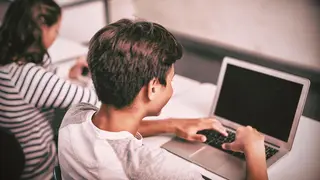 Student using laptop in classroom