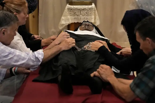 People queued for hours to see the nun's body and touch her with warnings to be 'careful of her feet'