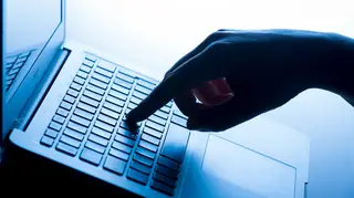 A woman’s hand pressing a laptop keyboard