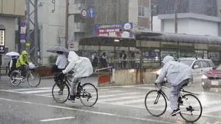 People make their way in strong rain in Kochi, southern Japan