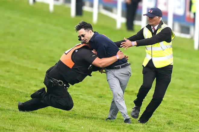 The protester was one of two arrested at the race