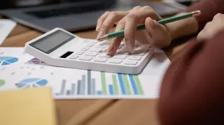 Close-up view of bookkeeper or financial inspector making report, calculating or checking balance