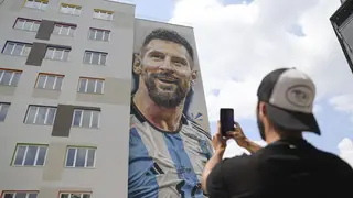 Argentinian street artist Maximiliano Bagnasco takes a photo of a mural portraying Argentinian footballer Lionel Messi, that he painted, in Tirana, Albania