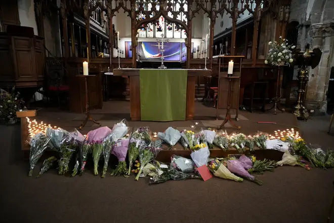 Flowers and candles lie at the altar after being placed by friends of the deceased during a vigil at St Peter’s Church