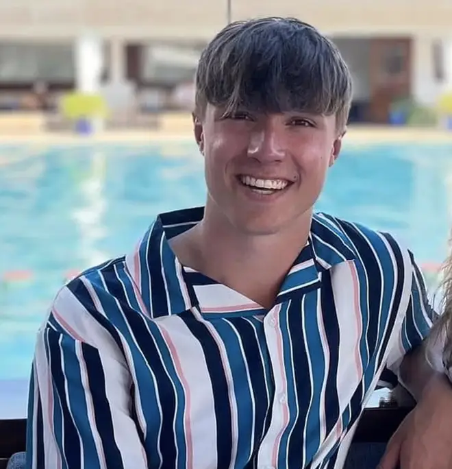 Barnaby Webber wearing a striped shirt smiling while on holiday