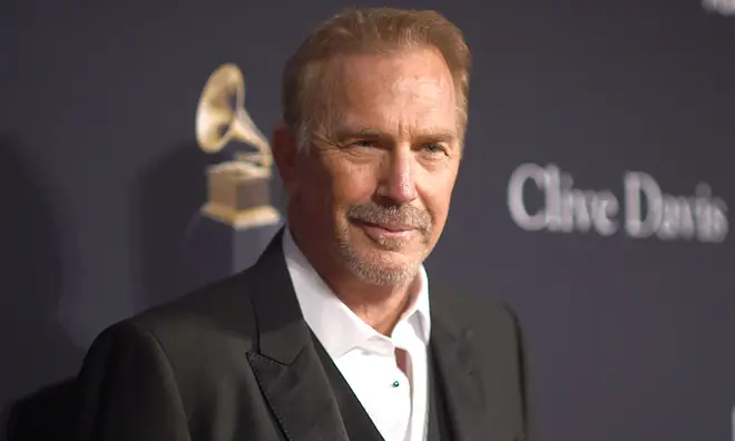 Kevin Costner wearing a black blazer and white shirt on the red carpet
