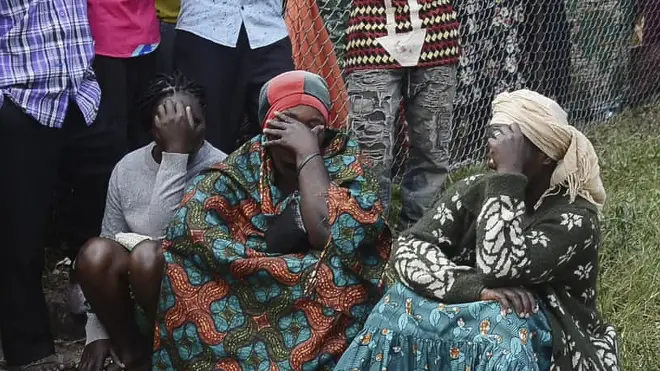 Residents are seen at the premises of an attack in Mpondwe, Uganda